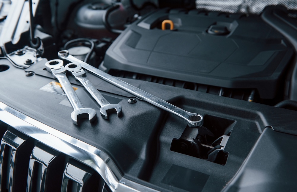 Spanners resting on a car engine cover in the Basingstoke mechanic workshop